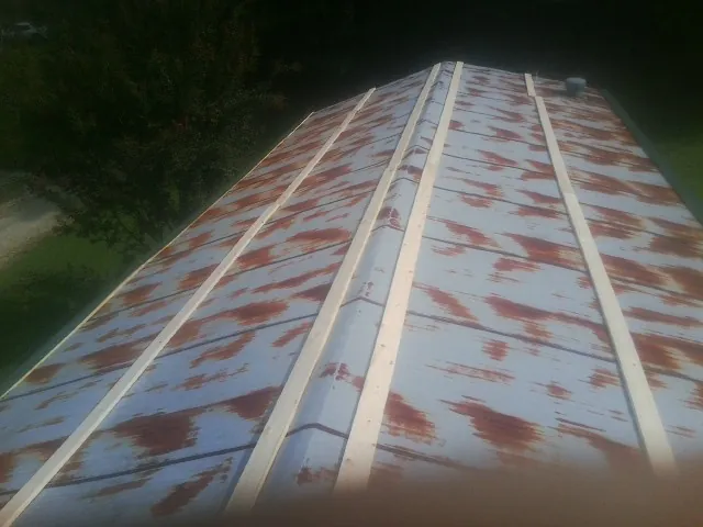 Rusted metal roof panels with new wood purlins before replacement — Storm Damage Roof Repair in Brighton by Roofing Brothers
